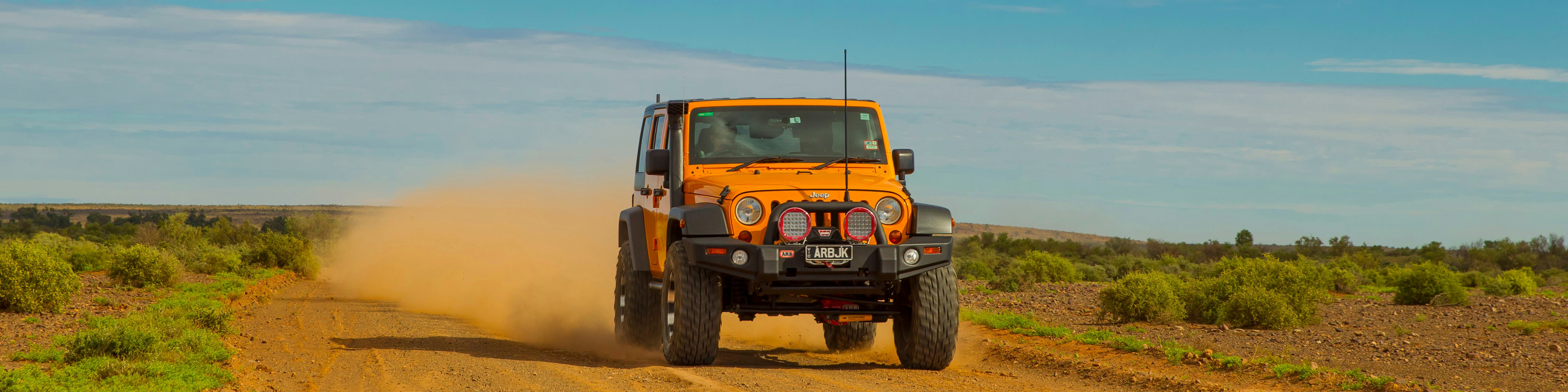 Yellow 4x4 with ARB accessories driving in the outback